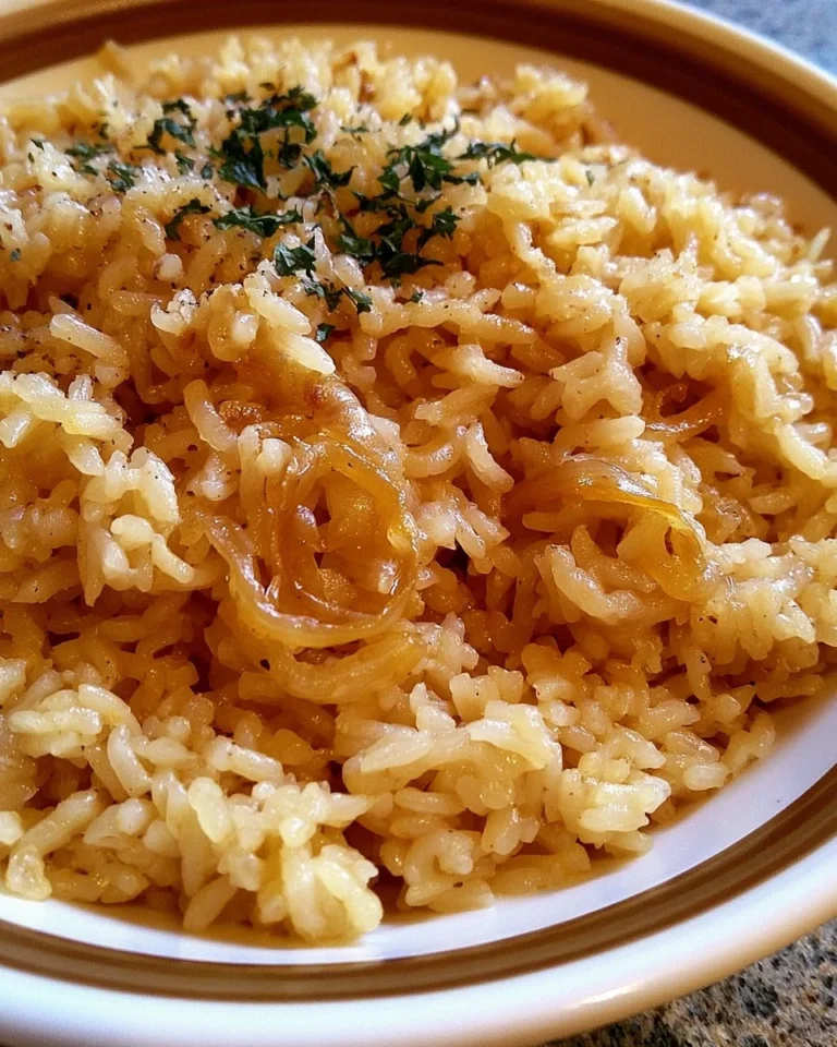 Dish of buttery onion rice garnished with fresh herbs